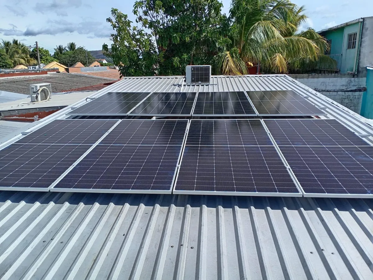 Instalación de paneles solares a escala comercial en un techo de metal en El Salvador